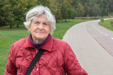 Senior woman walking in autumn park