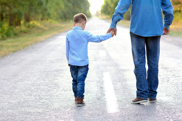 Obraz premium A Happy parent with a child in the park hands on nature travel go along the road