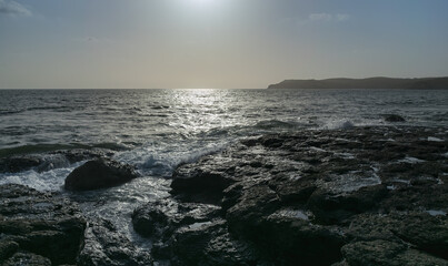 Obraz premium Panoramic view of sea waves flowing and foaming into rocks of Velneshwar beach, India