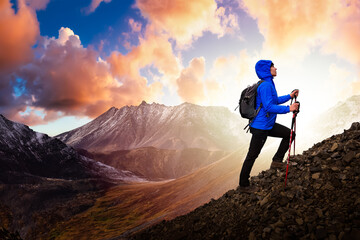 Adventurous Girl Hiking in the Canadian Mountains. Dramatic Colorful Sunset Artistic Render and Adventure Composition. Background Landscape from Tombstone Territorial Park, Yukon, Canada.