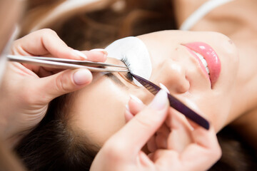 Beautician working on upgrading silk eyelashes in a beauty studio.