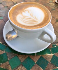 coffee with milk foam on a mosaik table