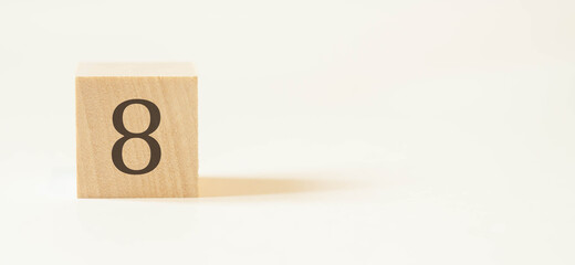 Number eight on a wooden cube with a white background.