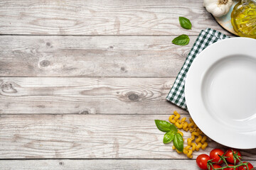 Food cooking background with vegetables, pasta and empty white plate