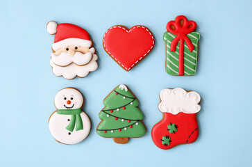 Different Christmas gingerbread cookies on light blue background, flat lay