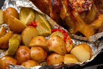 baked meat and potatoes on a baking sheet, pork knuckle delicious food