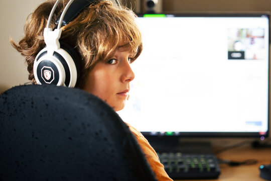 child boy learning with the Zoom sitting and listen with the computer at home