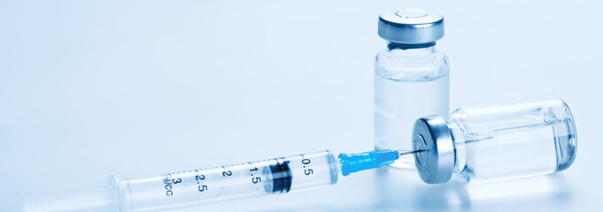 Medical syringe with a needle and a bollte with vaccine. - 389721764