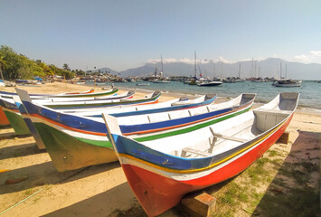 Naklejka na ściany i meble Amazing colored bots in the beach in Ilha Bela, Sao Paulo, Brazil. Summer day, beautiful beach , cool island