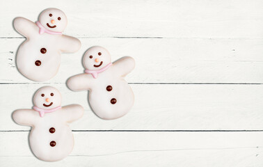 Delicious Christmas cookies in the shape of snowman decorated with icing sugar and fondant on a...
