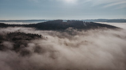 Aerial view of morning foggy landscape. Fall autumn peaceful scenery. Misty calm atmosphere. Drone photo of Czech mountain Velky Blanik. Trees in fog. Fairy tale land.Meditation dreamy concept