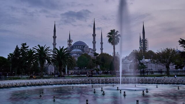 Sultanahmet region in evening with Blue Mosque (Sultanahmet Cami),  clouds and people around pool. Time lapse clip.