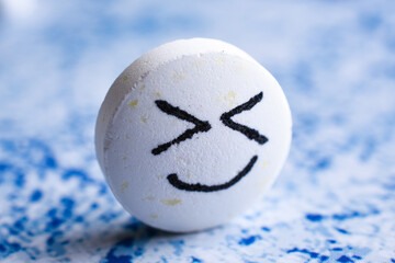 Big white cute Pill with drawn face smile on color background. the concept of antidepressants
