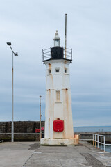Anstruther lighthouse in Scotland. Vertical photograph. Cloudy day.