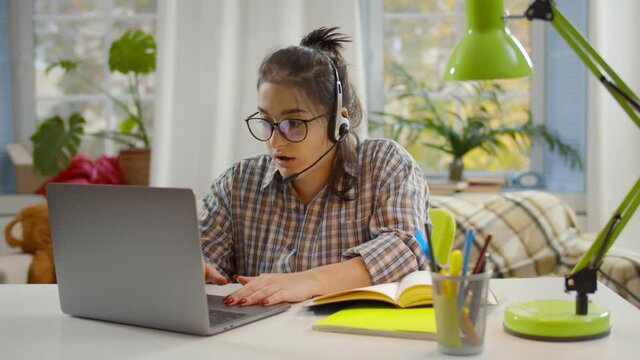 Young mother work at home having video call with kids playing in living room.