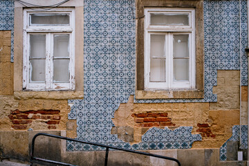 Damaged buildig covered in traditional azulejos tiles in Lisbon, Portugal