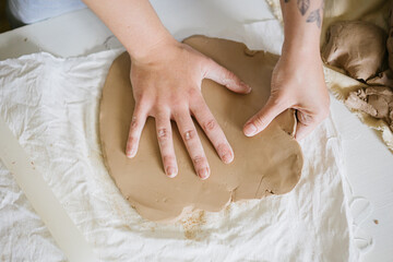 young curly girl in a pottery workshop makes a vase