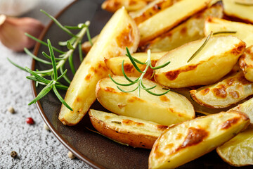 Fresh baked red potatoes with rosemary and garlic on brown plate