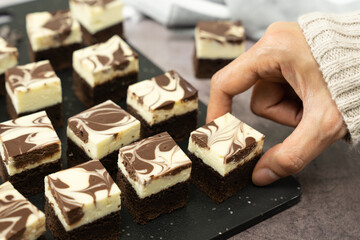 Cutting of homemade cheesecake swirl brownie or fudge
