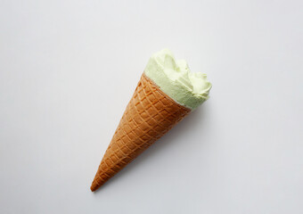 Pistachio flavored ice cream cone isolated on white background from a high angle view