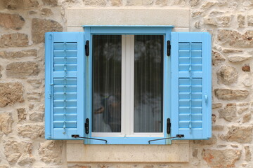 Fototapeta na wymiar Blaue Fensterläden auf Sandstein