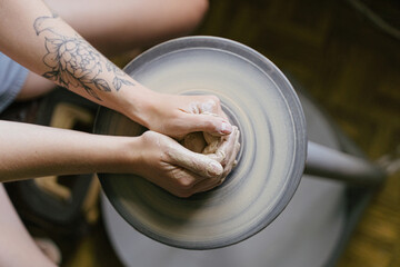 young curly girl in a pottery workshop makes a vase