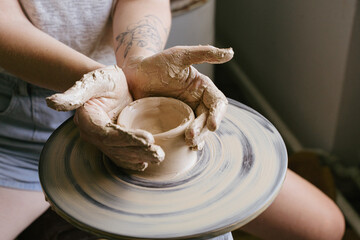 young curly girl in a pottery workshop makes a vase