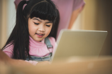 Asian father and mother teaching daughter homework, Parents helping their daughters with homework at home