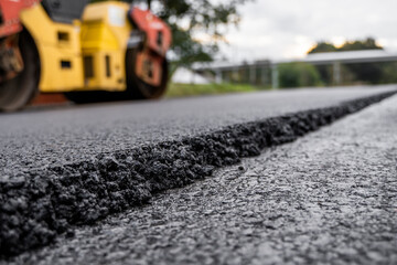 Asphalt road roller with heavy vibration roller compactor press new hot asphalt on the roadway on a...