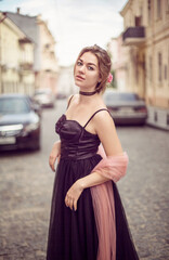
A girl in a long black dress walks through the old city
