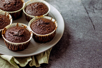 Homemade gluten-free muffins with chocolate close-up. Gluten-free flour cupcakes with chocolate on a green plate with a napkin on a dark table. Low Carb Sugar Free Cupcakes