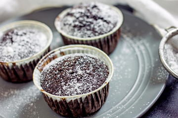 Homemade gluten-free muffins with chocolate close-up. Gluten-free flour cupcakes with chocolate on a green plate with a napkin on a dark table. Low Carb Sugar Free Cupcakes