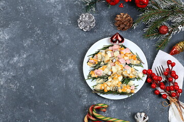 Christmas new year food, traditional festive olivier salad with fir branches and cones and decorations on concrete table, idea for food design, place for recipe, flat lay,