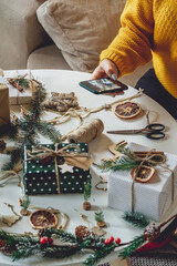 Female hands take photo with mobile phone of christmas decoration