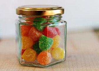 Fototapeta na wymiar Caramelos de goma de colores en frasco con foco selectivo.