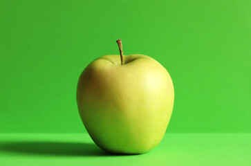 One green apple isolated on green background
