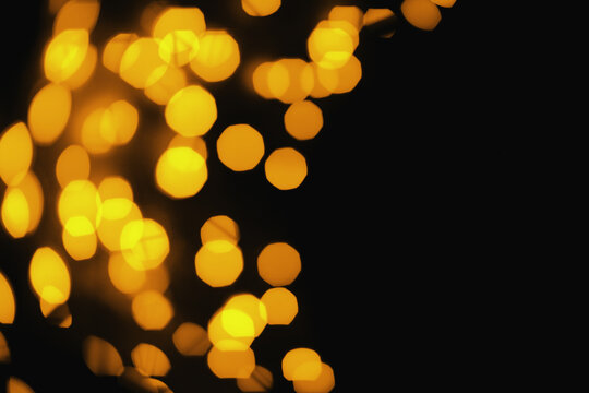 golden bokeh on black background, christmas lights. Free plase for text