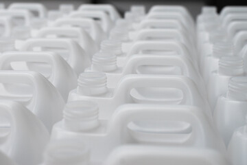 Fototapeta premium Rows of white plastic canisters ready to be filled with chemicals