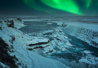 beautiful Snowy landscape at night at Gullfoss Falls with Northern Lights in Iceland during Christmas