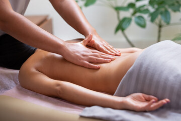 Caucasian woman getting a back massage in the spa salon