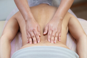 Fototapeta na wymiar Caucasian woman getting a back massage in the spa salon