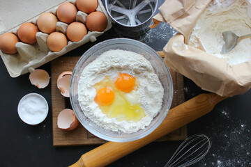 A bowl of flour and egg on the kitchen table.Preparation of home-made dough. Baking ingredients