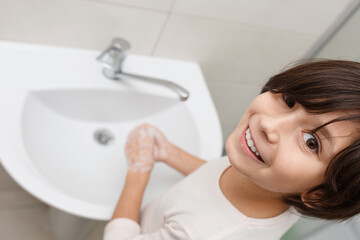 Teenage girl washes her hands.