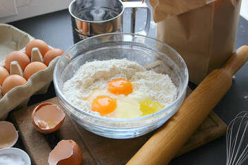 A bowl of flour and egg on the kitchen table.Preparation of home-made dough. Baking ingredients