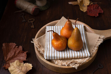 Three Fresh Pears on a Wooden Tray in a Rustic Tabletop Setting