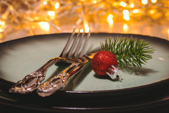 Weihnachtliches Arrangement von Besteck und Teller mit leuchteten Bokeh im Hintergrund