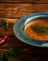 chicken broth with dill on wooden background
