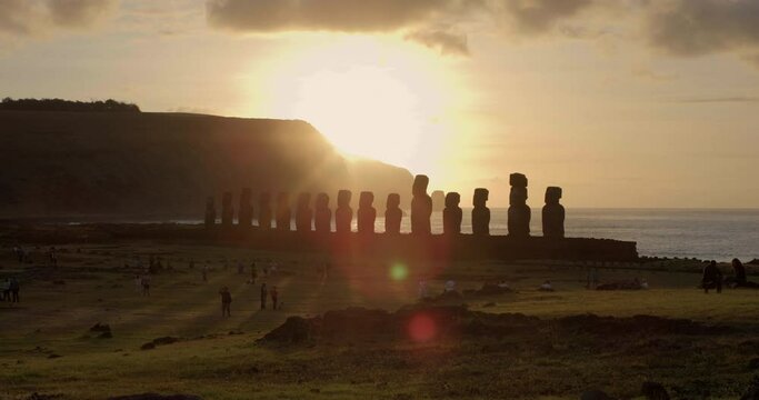 Tourists admire Easter Island heads at sunset, wide shot
