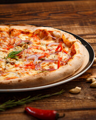 Pizza with holopeno, onion and cheese on wooden background