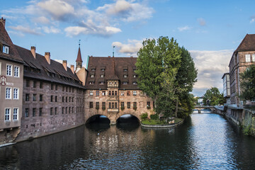 Fototapeta premium Ancient Nurnberg Heilig Geist Spital building (Hospital of the Holy Ghost, 1339) over Pegnitz river. View from the Bridge on the River Pegnitz. Nuremberg, Germany.